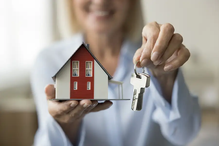 Mature woman real estate agent, realtor handing over the keys to your new home - Springfield, IL